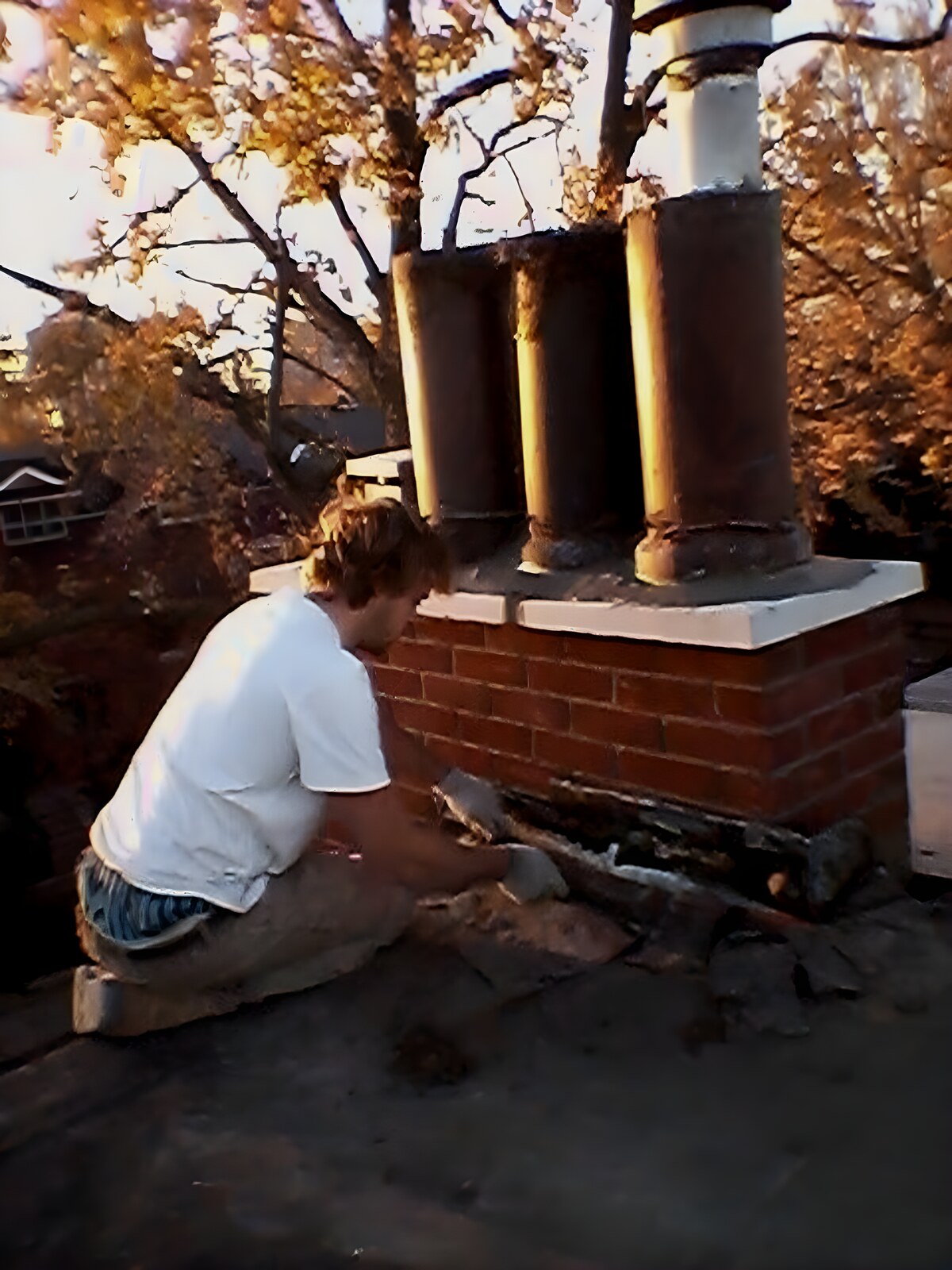 Greg Krolicki rebuilding a brick chimney at golden hour in Toronto